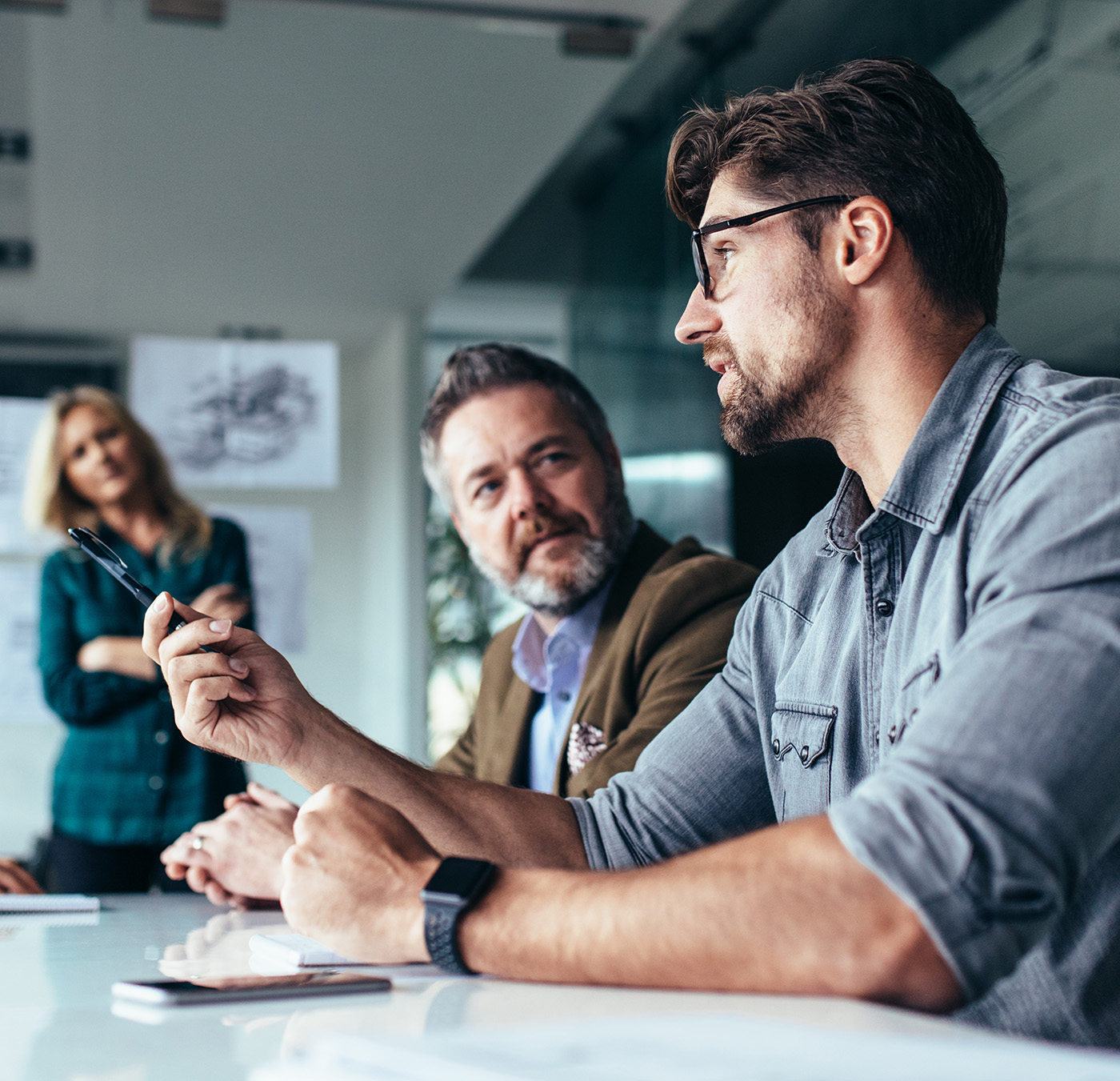 Group of three people sitting at a table having a meeting